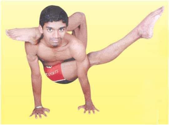 Yogi demonstrating advanced arm balance with leg behind neck (Dwi Pada Sirsasana variation) during competition preparation
